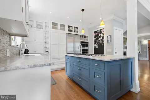 a kitchen with stainless steel appliances granite countertop a sink a oven and a large refrigerator