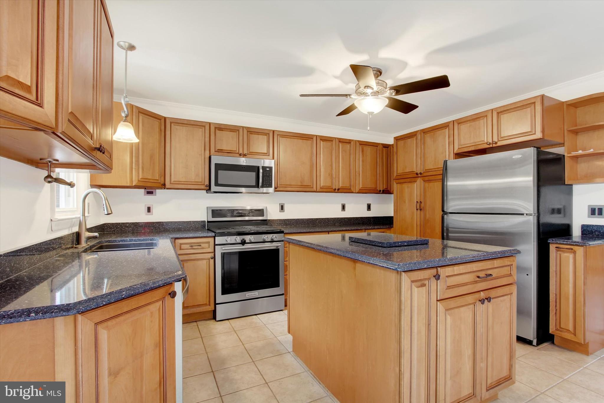 5206 Rockery Road Spring Grove, PA 17362 - Photo 15 of 28 a kitchen with stainless steel appliances granite countertop a sink a stove a refrigerator cabinets and chairs