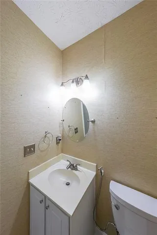 a bathroom with a sink mirror and toilet