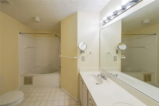 a bathroom with a bathtub shower sink mirror and toilet
