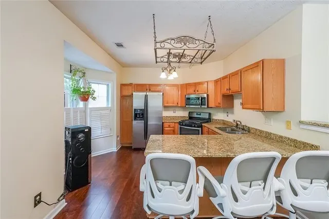 a view of a dining room with furniture a chandelier and wooden floor