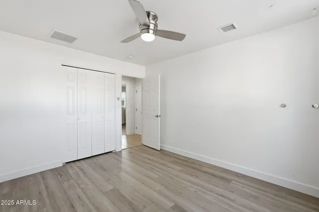 a view of an empty room with wooden floor