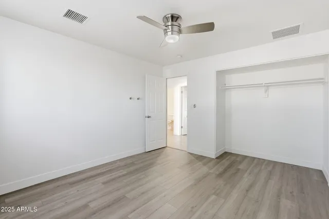 a view of a room with wooden floor and ceiling fan