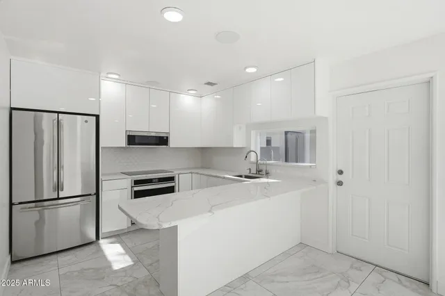 a kitchen with a refrigerator a sink and cabinets