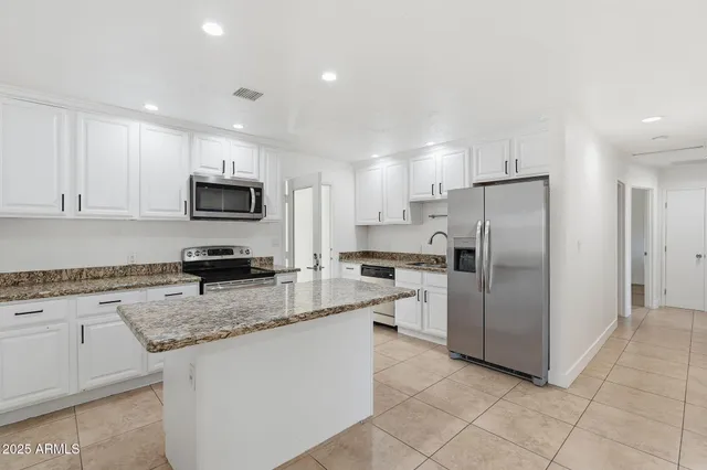 a kitchen with stainless steel appliances granite countertop a refrigerator stove microwave and sink