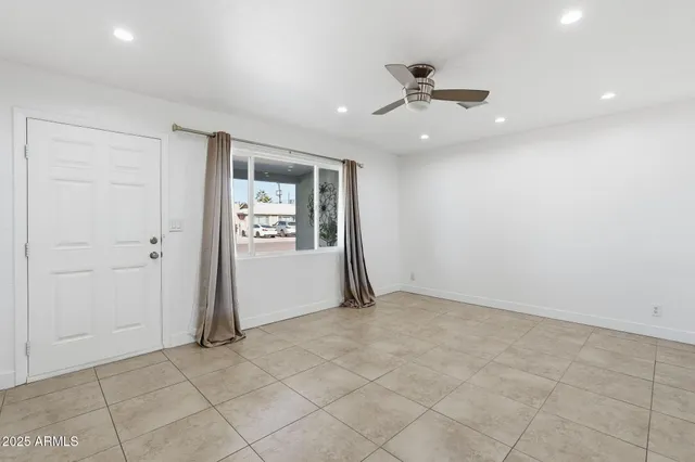 an empty room with windows and ceiling fan