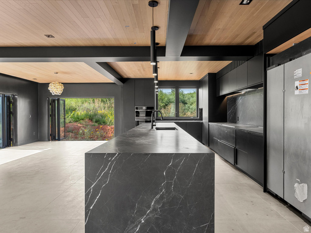 2610 Foxridge Road Garden City, UT 84028 - Photo 30 of 71 Kitchen featuring a waterfall island with a dark stone finish, integrated appliances, wood-finish ceiling, bi-fold doors, and recessed and pendant lighting