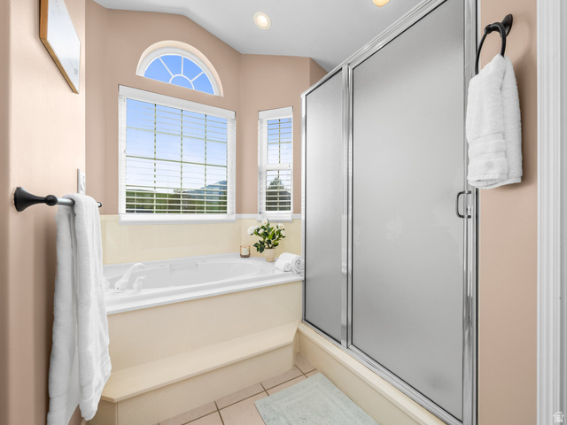 6849 North Black Powder Road Mountain Green, UT 84050 - Photo 16 of 43 Bathroom featuring a built-in soaking tub with tiled surround, an arched accent window, and a separate shower with frosted glass doors