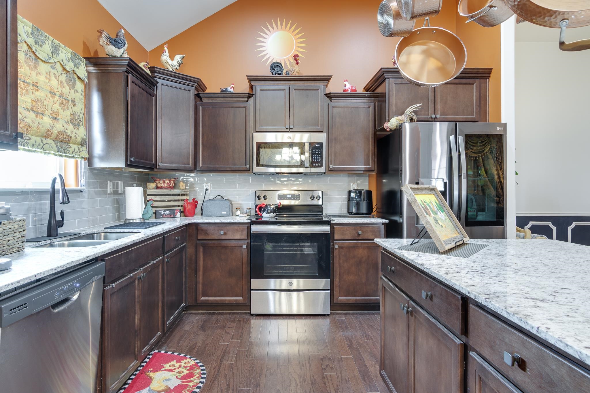 135 Chesnut Rdg Drive Oakland, TN 38060 - Photo 10 of 36 Kitchen featuring stainless steel appliances, dark wood finish cabinets, dark wood-style floors, light stone counters, and lofted ceiling