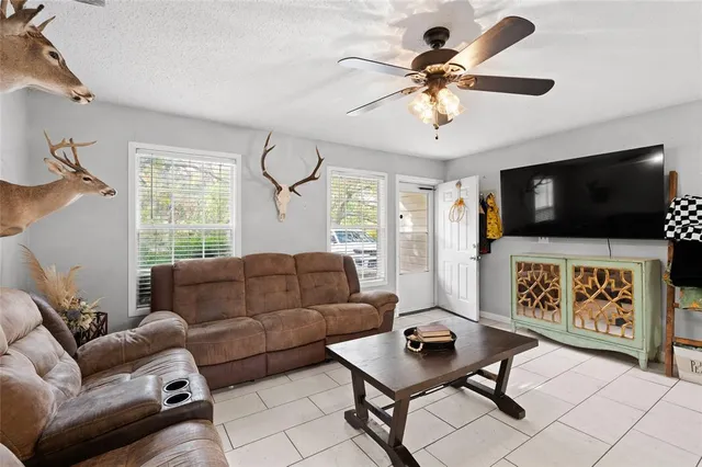 a living room with furniture a flat screen tv and a window