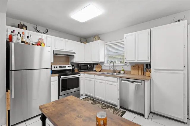 a kitchen with cabinets a refrigerator and white stainless steel appliances