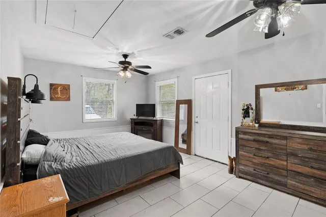 a spacious bedroom with a bed and a dresser with the carpet