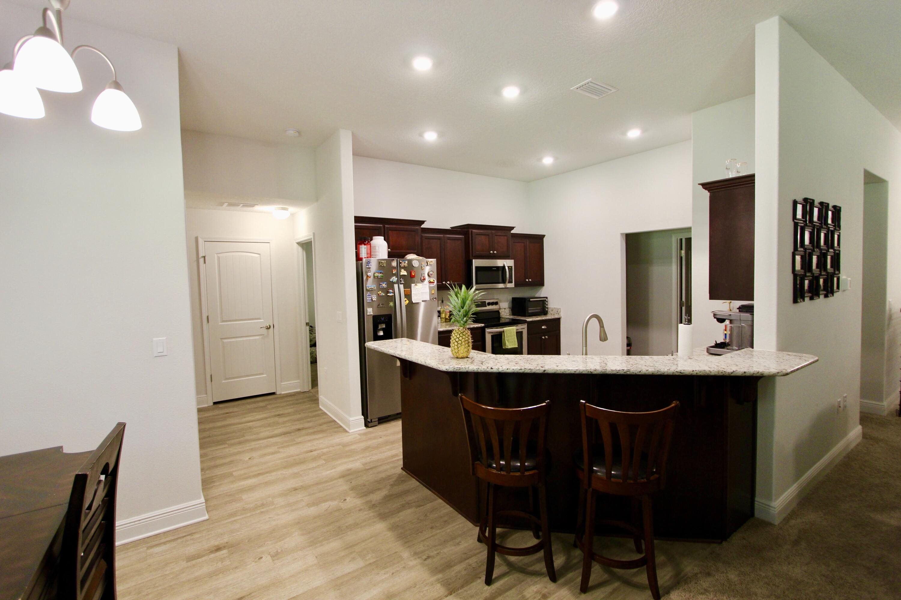 5759 Marigold Loop Crestview, FL 32539 - Photo 12 of 29 a kitchen with stainless steel appliances granite countertop a sink and a refrigerator