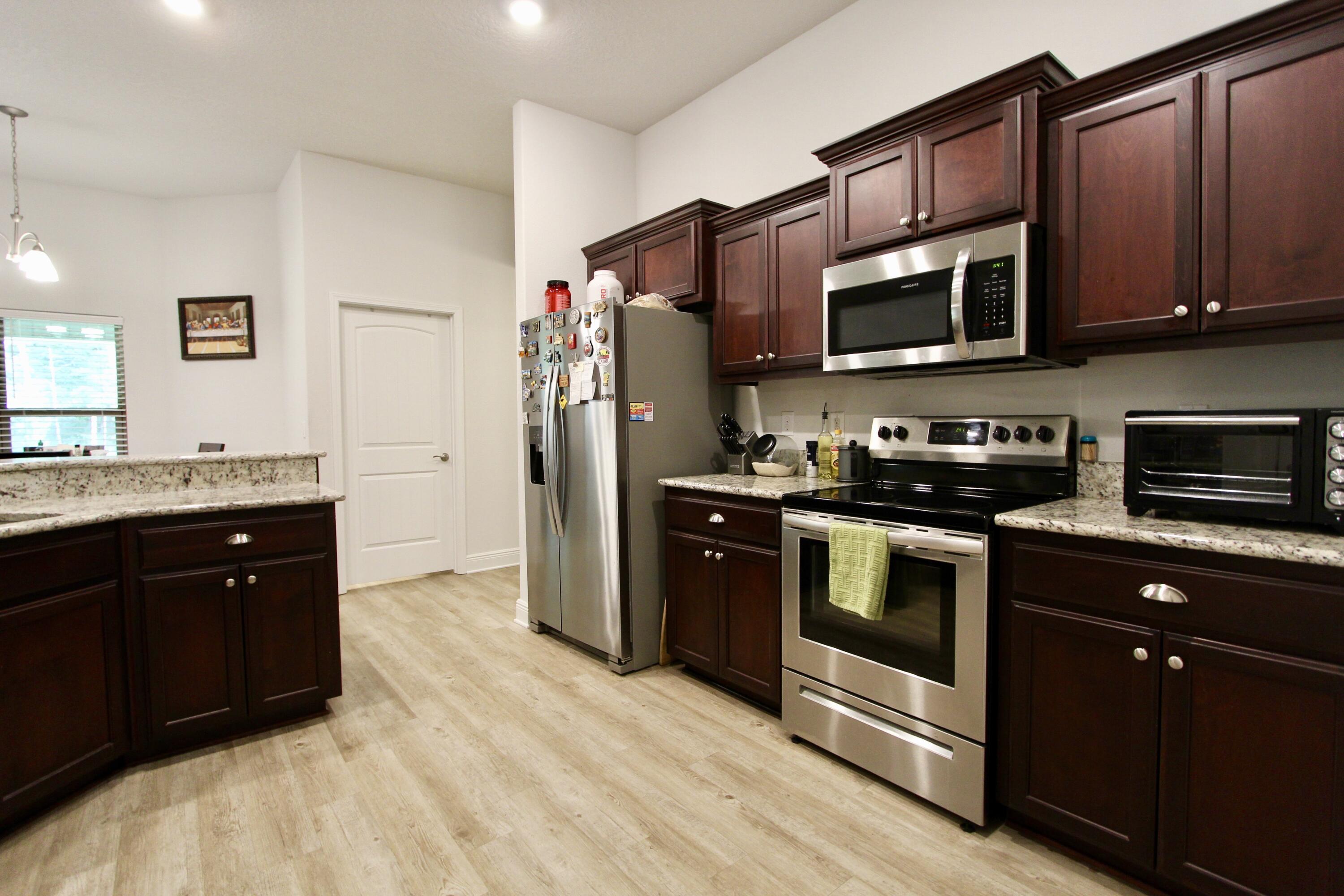 5759 Marigold Loop Crestview, FL 32539 - Photo 13 of 29 a kitchen with stainless steel appliances granite countertop a refrigerator and a stove top oven