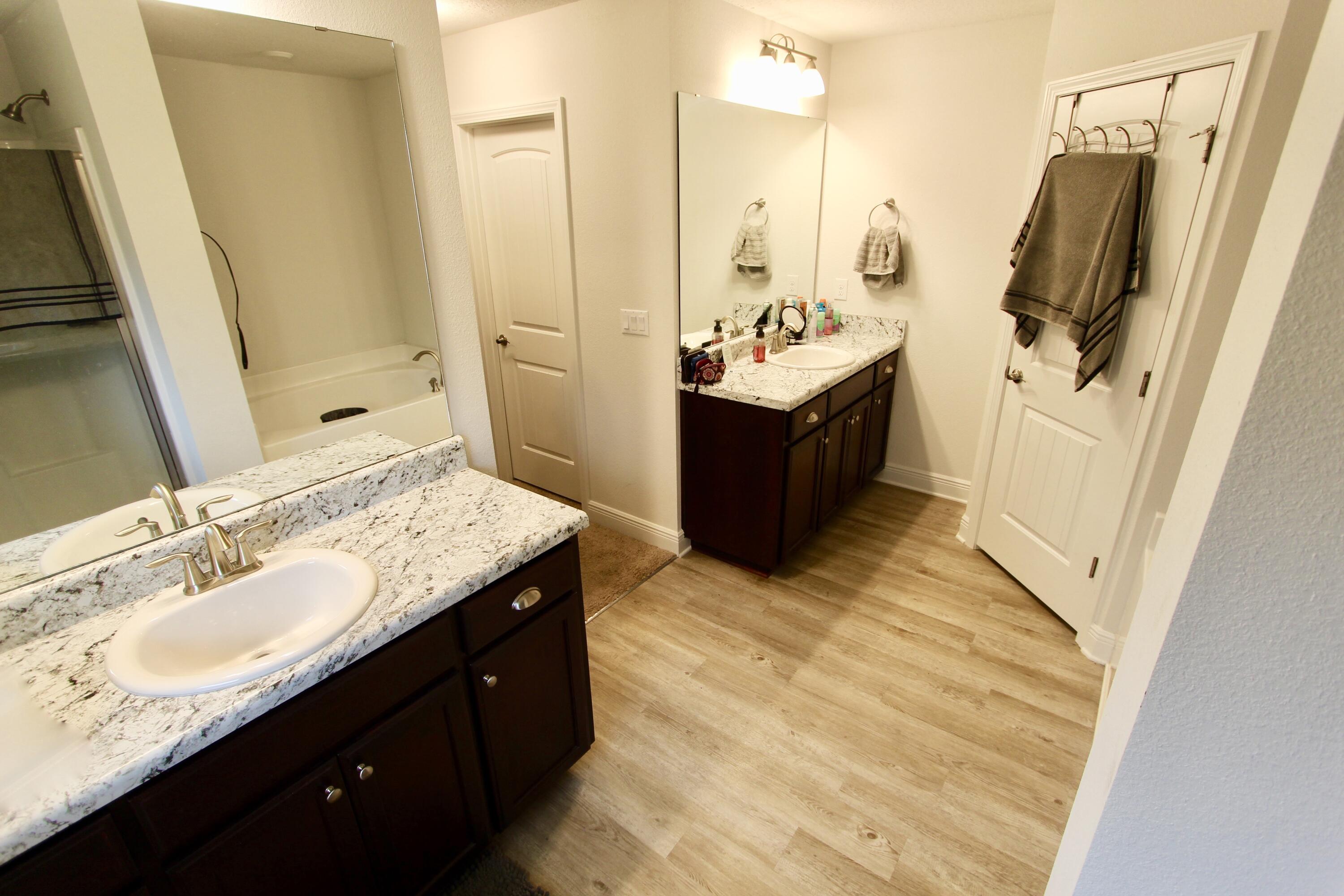 5759 Marigold Loop Crestview, FL 32539 - Photo 20 of 29 a bathroom with a double vanity sink a tub and mirror