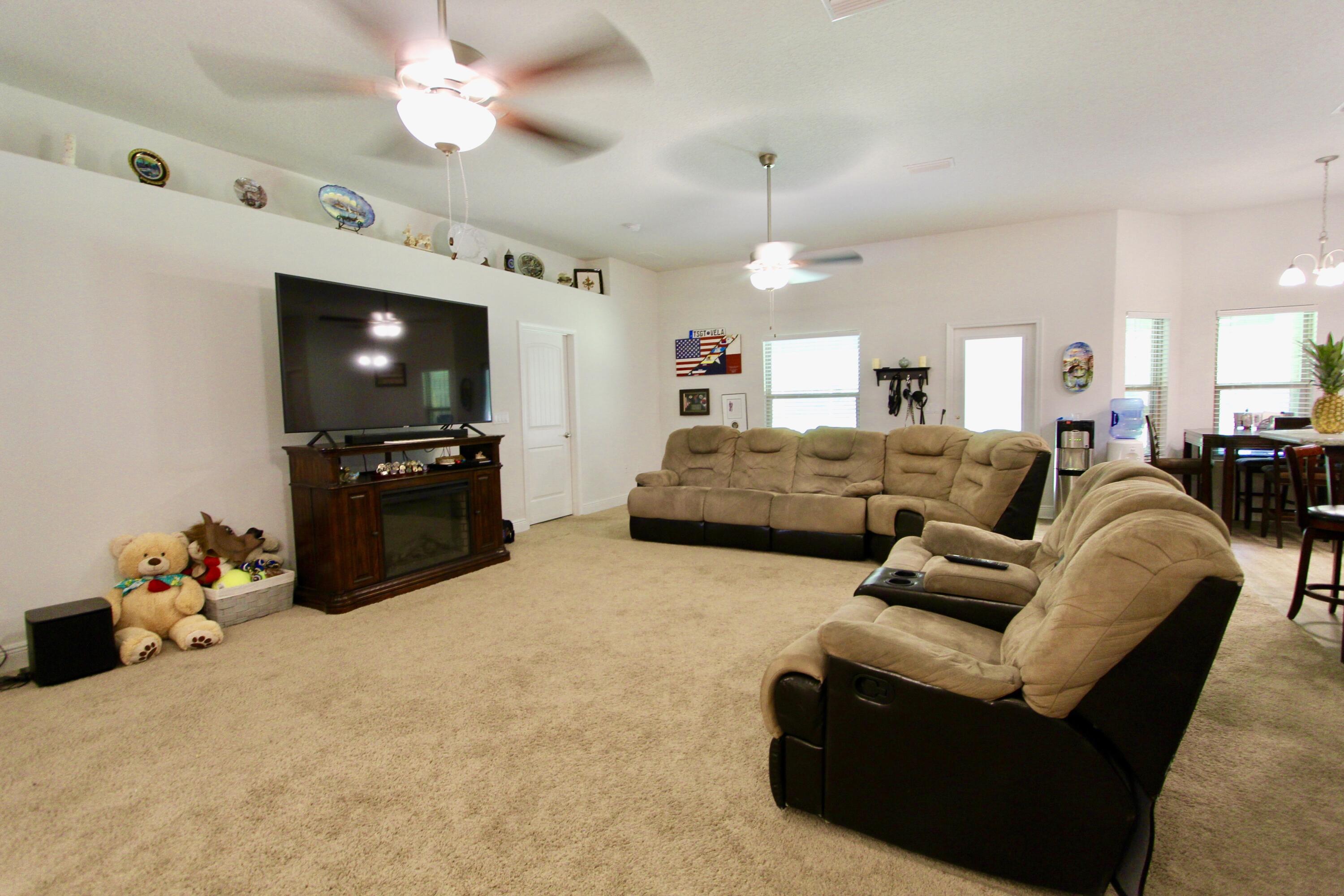 5759 Marigold Loop Crestview, FL 32539 - Photo 8 of 29 a living room with furniture a flat screen tv and kitchen view
