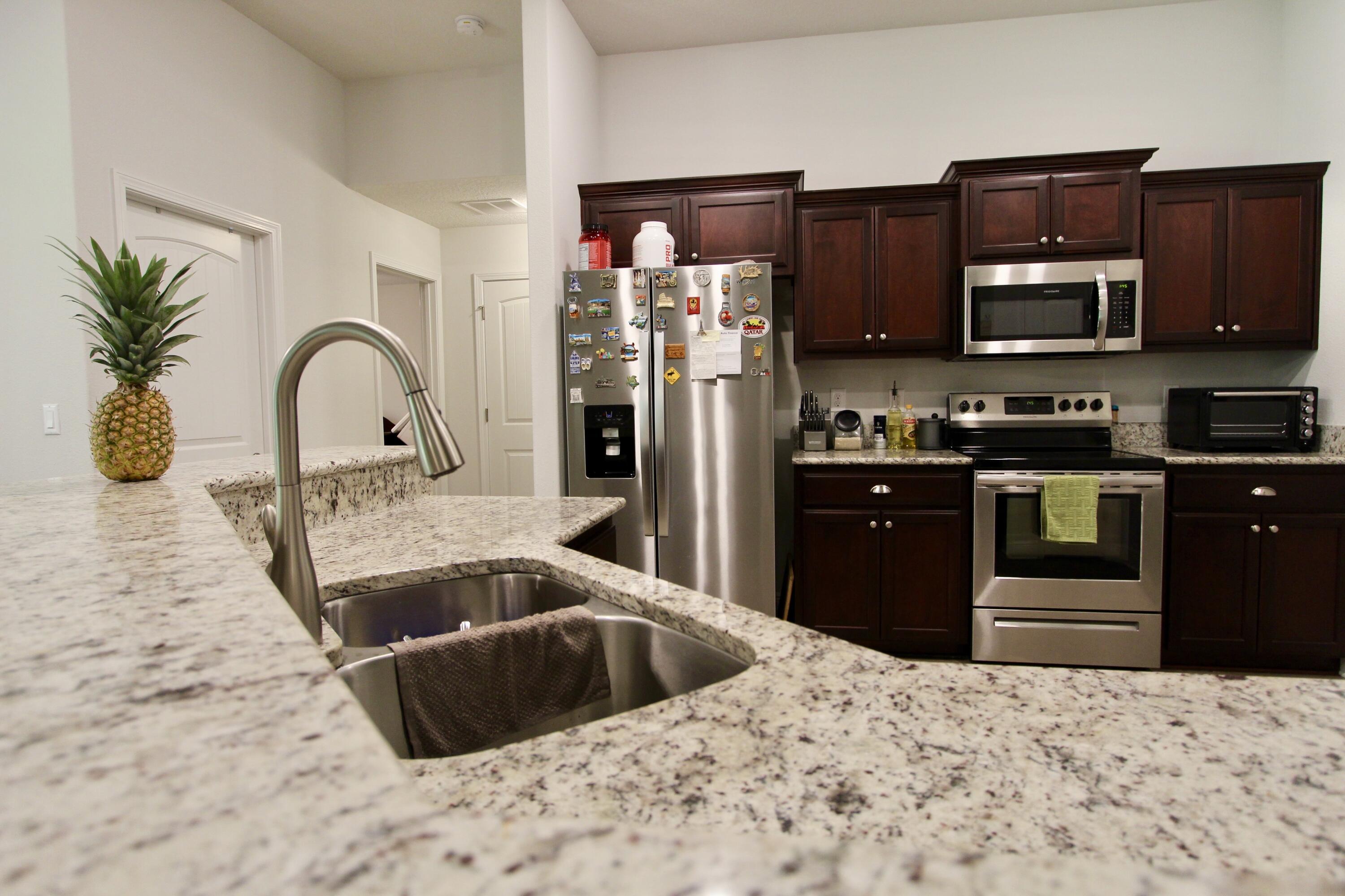 5759 Marigold Loop Crestview, FL 32539 - Photo 10 of 29 a kitchen with stainless steel appliances kitchen island granite countertop a refrigerator and a sink