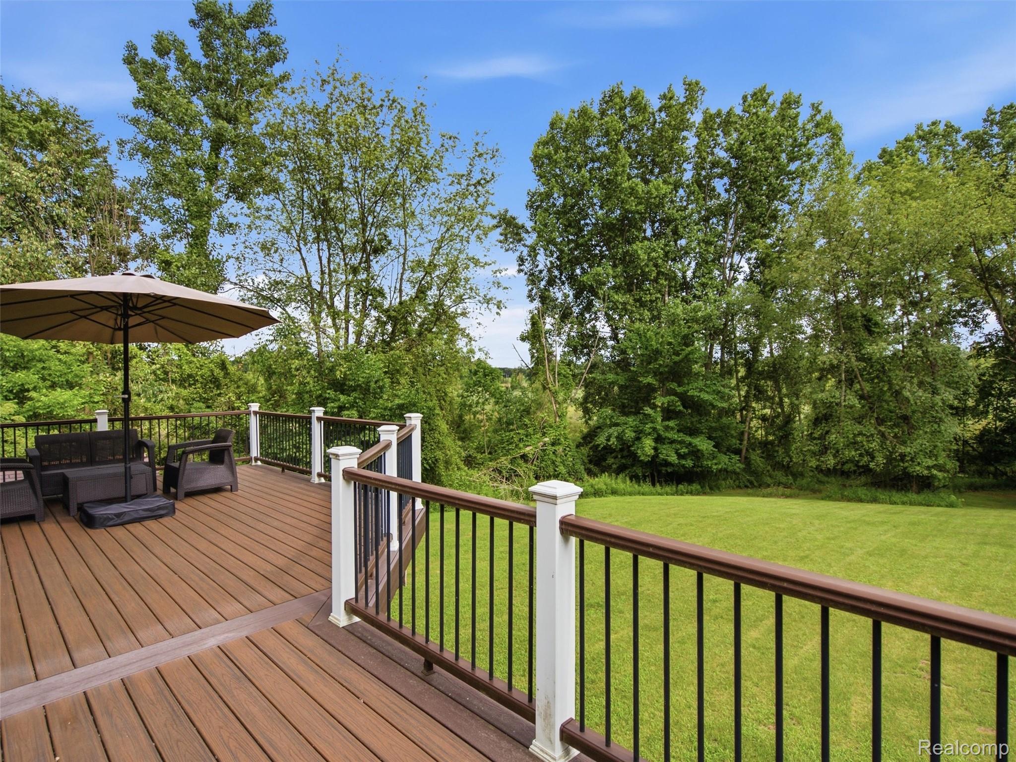 5003 Mason Road Howell, MI 48843 - Photo 41 of 59 Spacious outdoor deck featuring composite decking, white newel posts, and dark railing with metal balusters