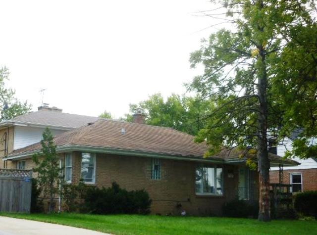 465 Iroquois Road Hillside, IL 60162 - Photo 2 of 8 a view of a white house next to a yard with big trees