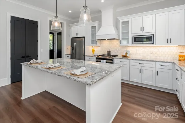 a kitchen with stainless steel appliances granite countertop a sink stove and refrigerator