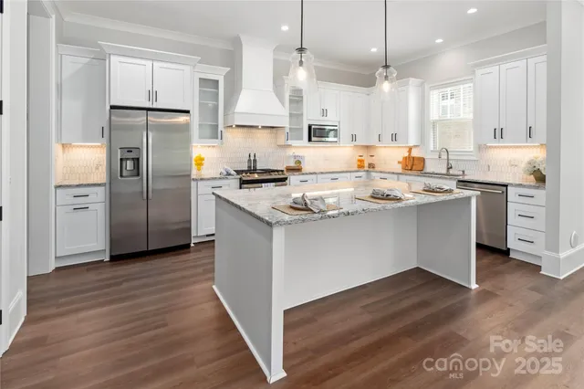 a kitchen with white cabinets stainless steel appliances and a counter space