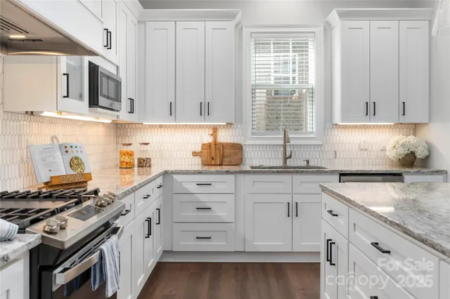 a kitchen with granite countertop a sink stove and cabinets