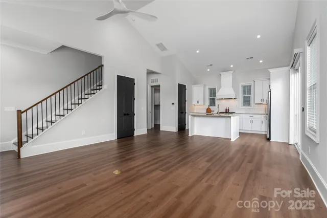 a open kitchen with white cabinets and wooden floor