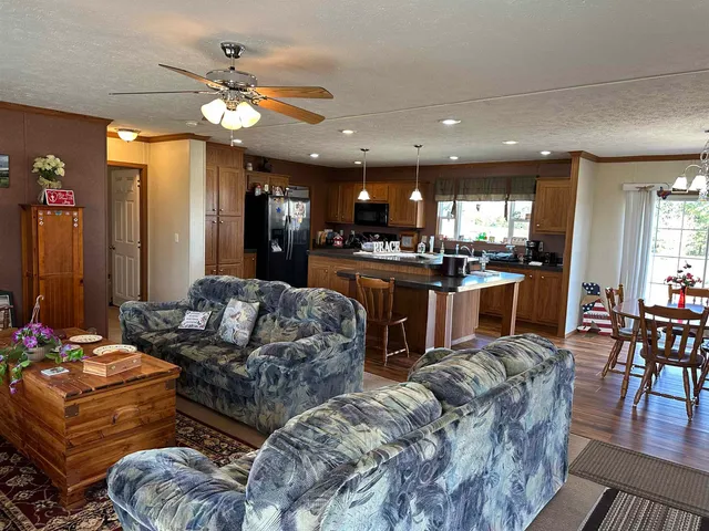 a living room with furniture kitchen and a chandelier