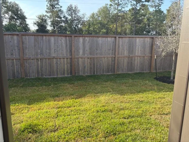 a view of a yard with a small cabin and wooden fence