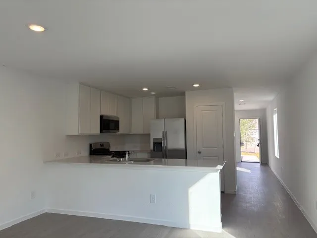 a large white kitchen with kitchen island sink and stove