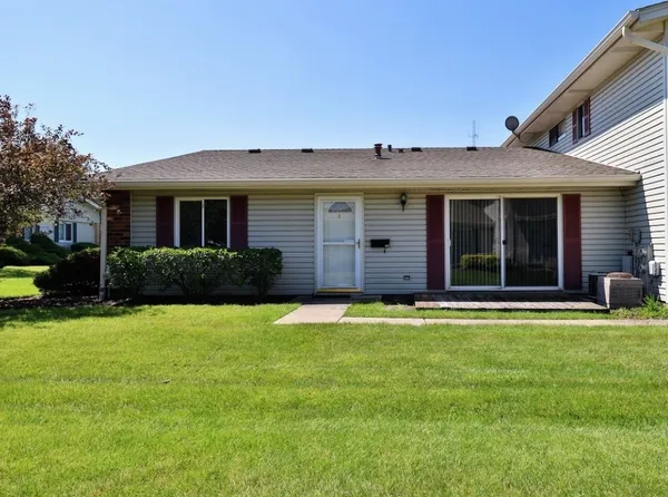a house that has a big yard with plants and large trees