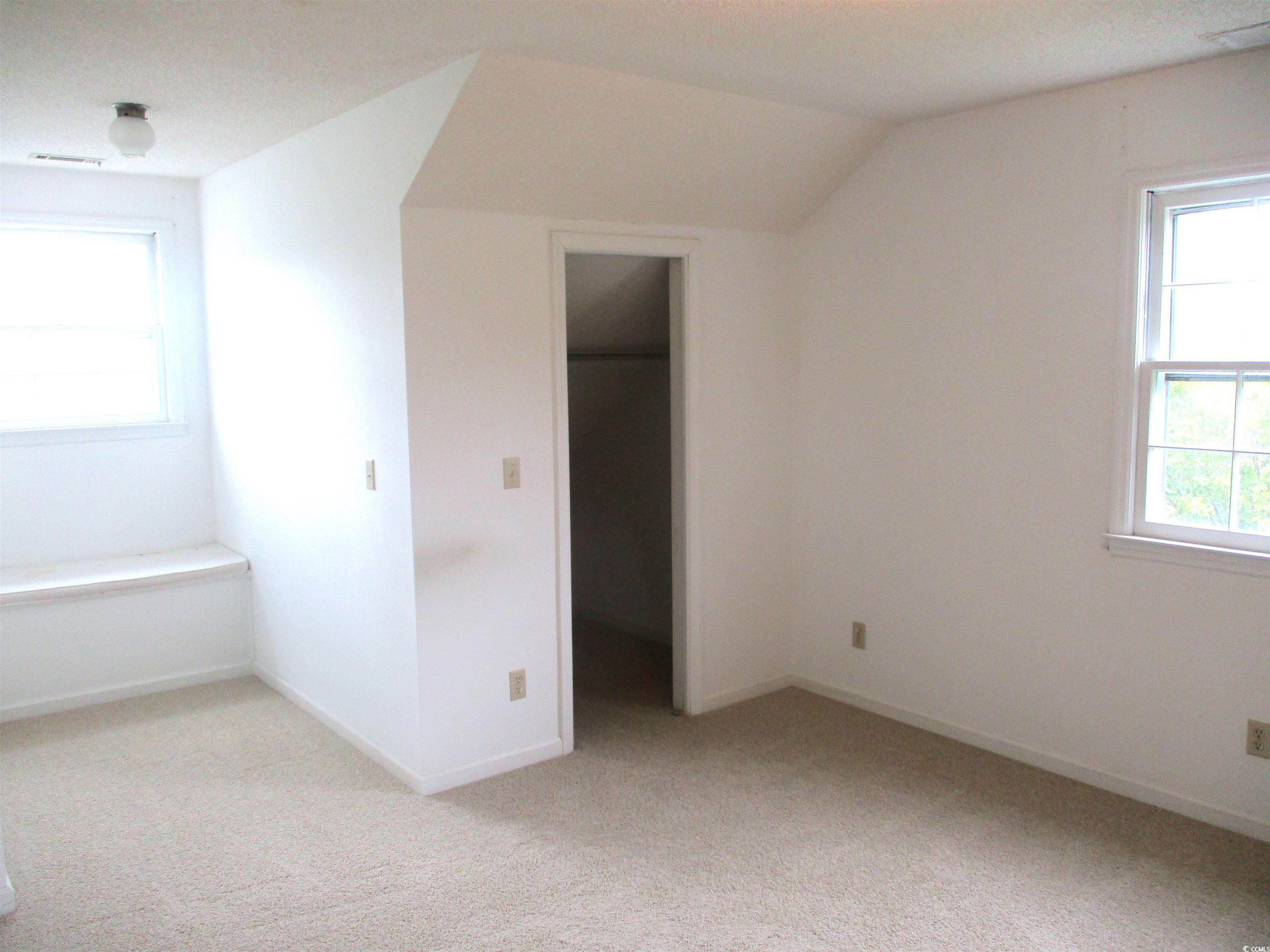 8110 Elvington Road Nichols, SC 29581 - Photo 13 of 17 Unfurnished bedroom with multiple windows, vaulted