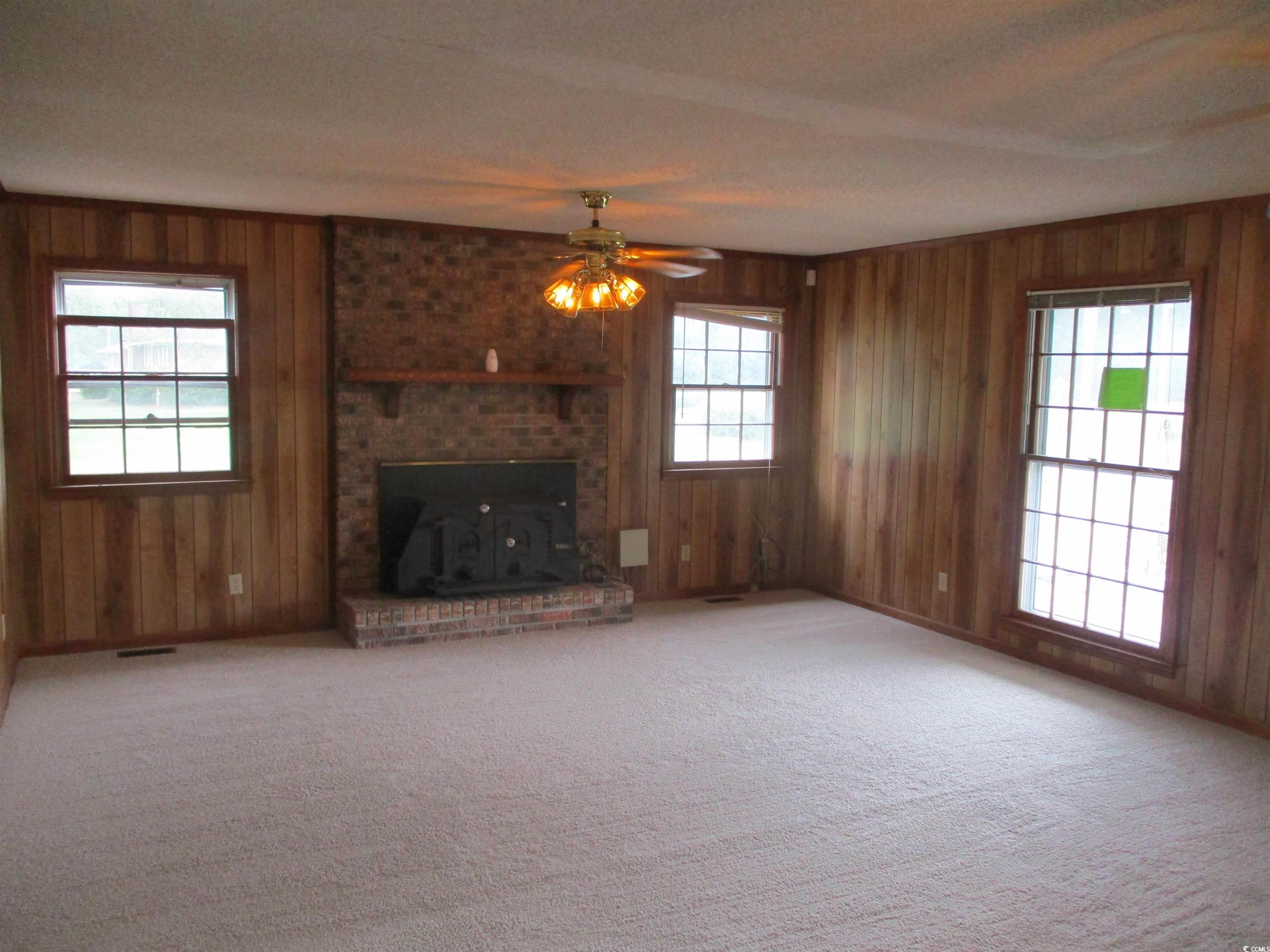 8110 Elvington Road Nichols, SC 29581 - Photo 10 of 17 Unfurnished living room with wood walls, ceiling f