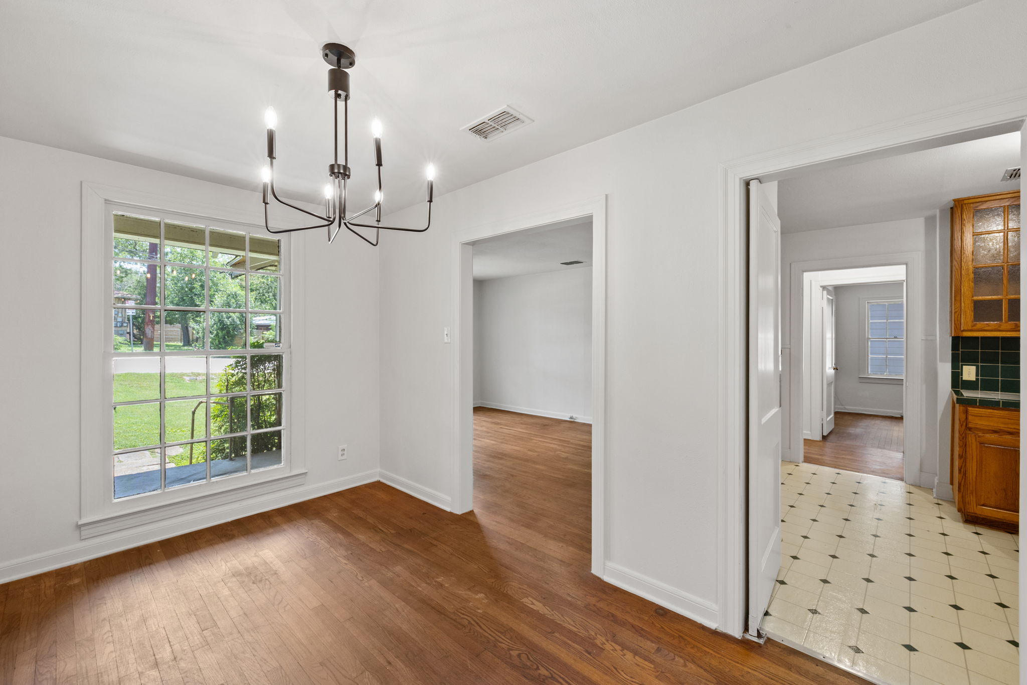 3704 Cherrywood Road Austin, TX 78722 - Photo 13 of 40 Natural light illuminates rich hardwood flooring, creating an easy flow to the kitchen and the living area.