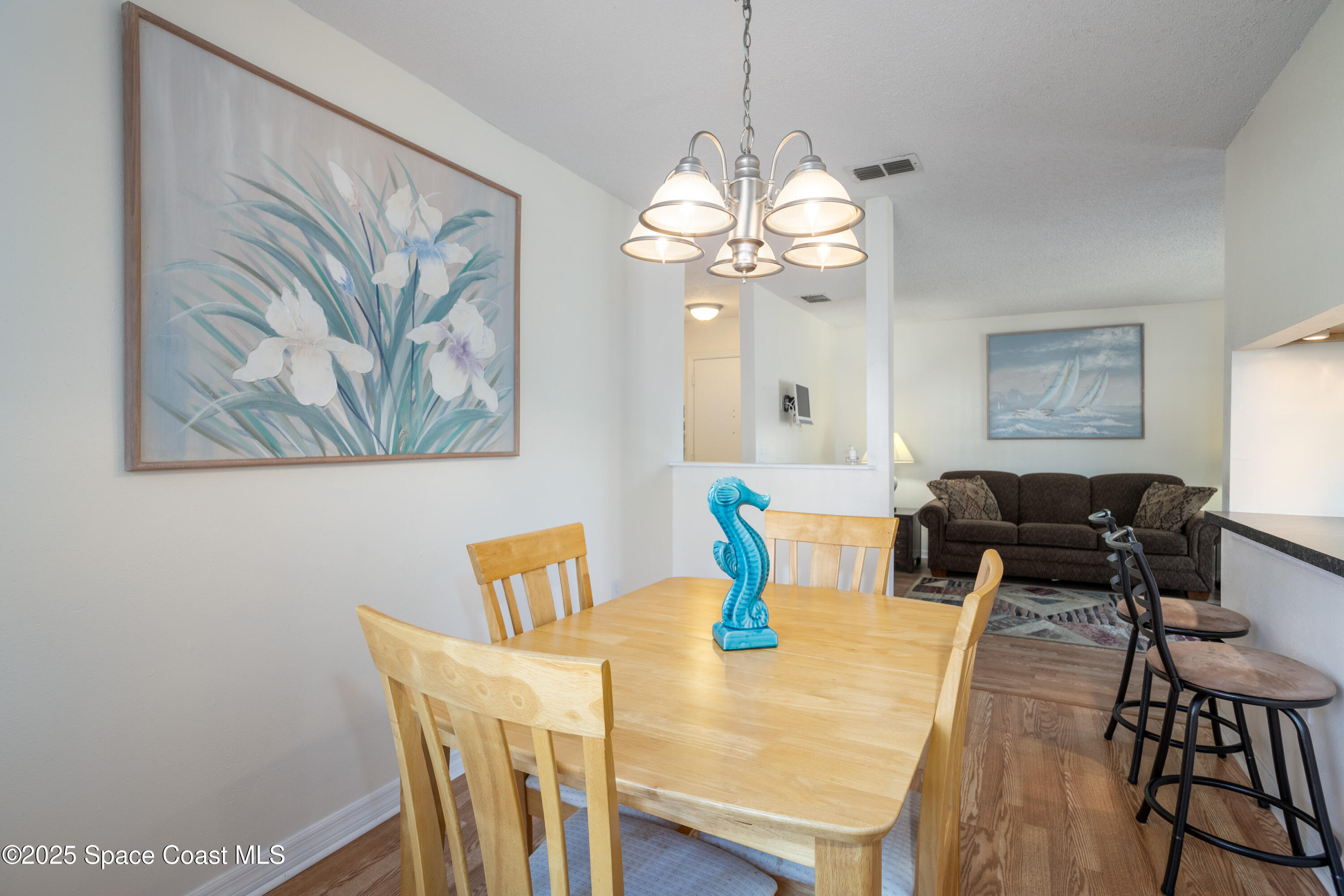 101 Summer Place, Unit 6 Merritt Island, FL 32953 - Photo 13 of 28 a view of a dining room with furniture a chandelier and wooden floor