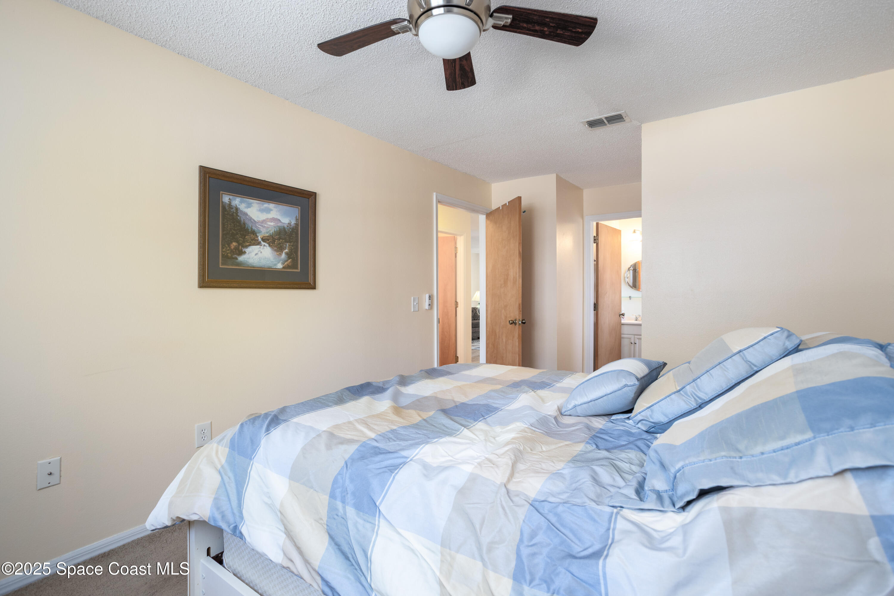 101 Summer Place, Unit 6 Merritt Island, FL 32953 - Photo 15 of 28 a bedroom with a large bed and a chandelier