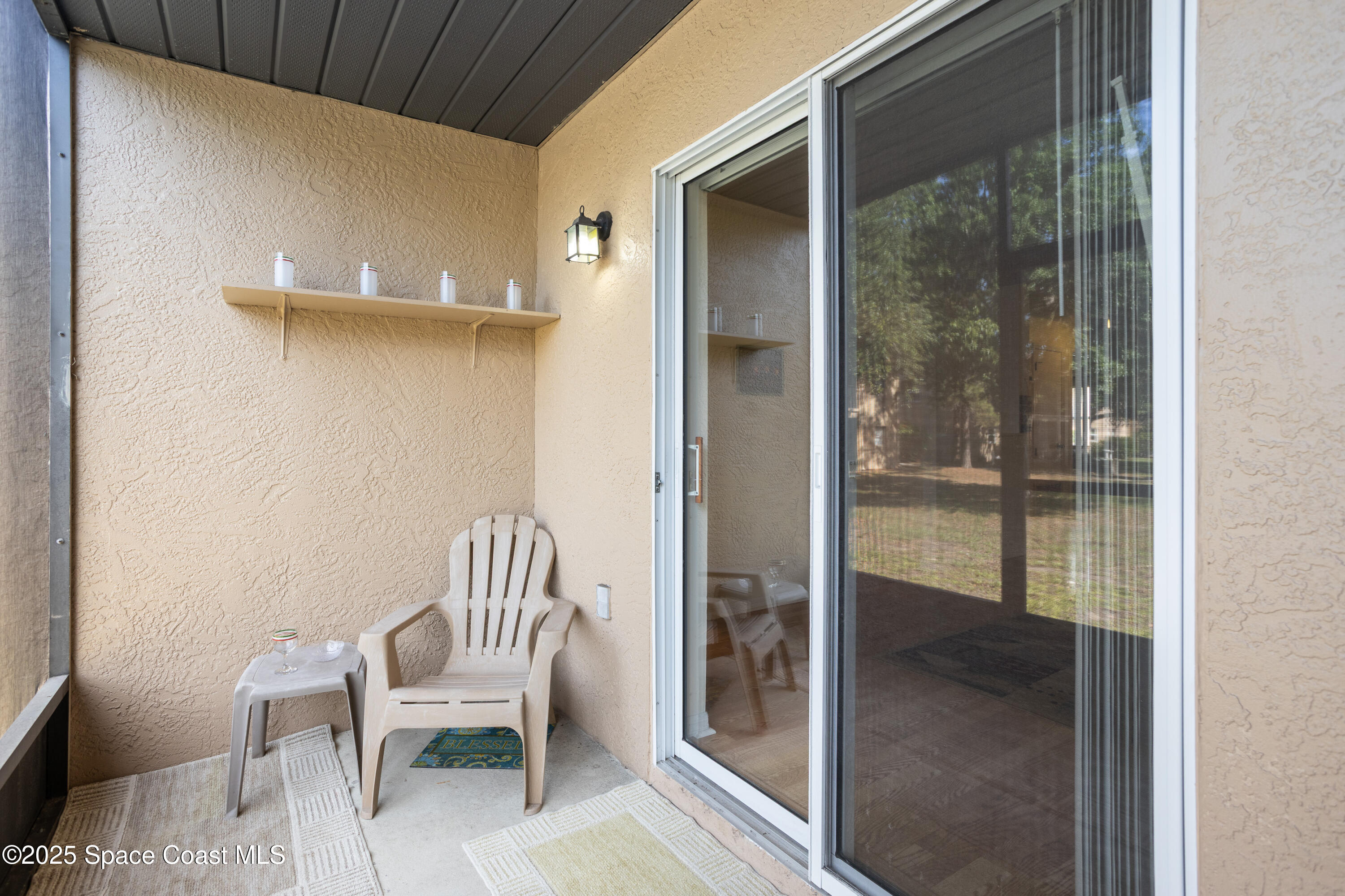 101 Summer Place, Unit 6 Merritt Island, FL 32953 - Photo 20 of 28 a room with a chair and glass door