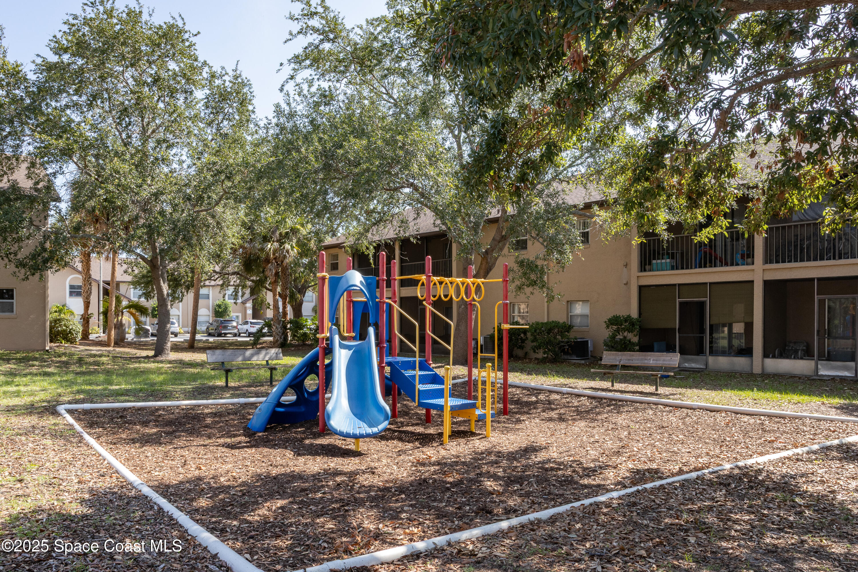 101 Summer Place, Unit 6 Merritt Island, FL 32953 - Photo 24 of 28 a view of a park with a slide and potted plants