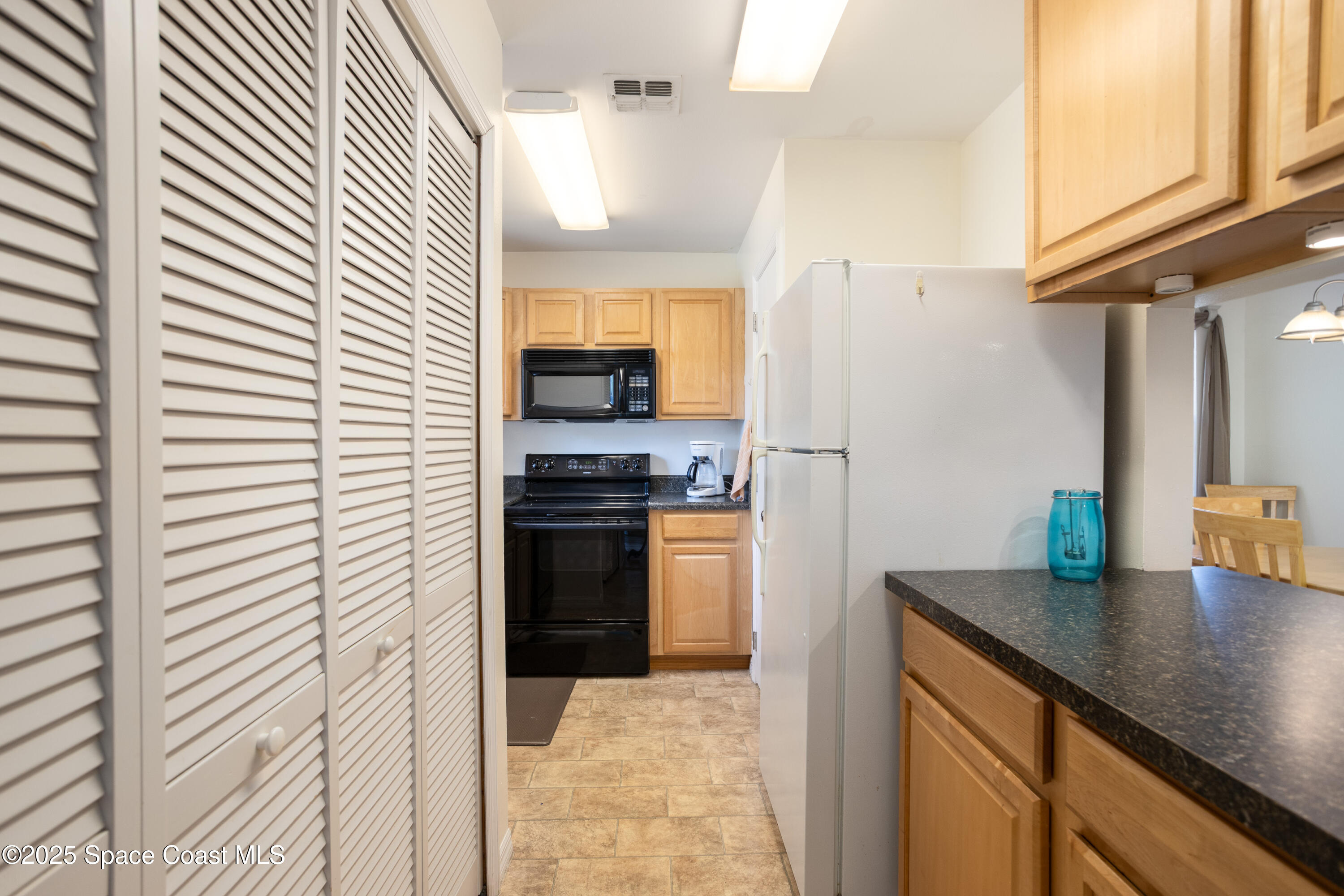 101 Summer Place, Unit 6 Merritt Island, FL 32953 - Photo 8 of 28 a kitchen with a refrigerator and a sink