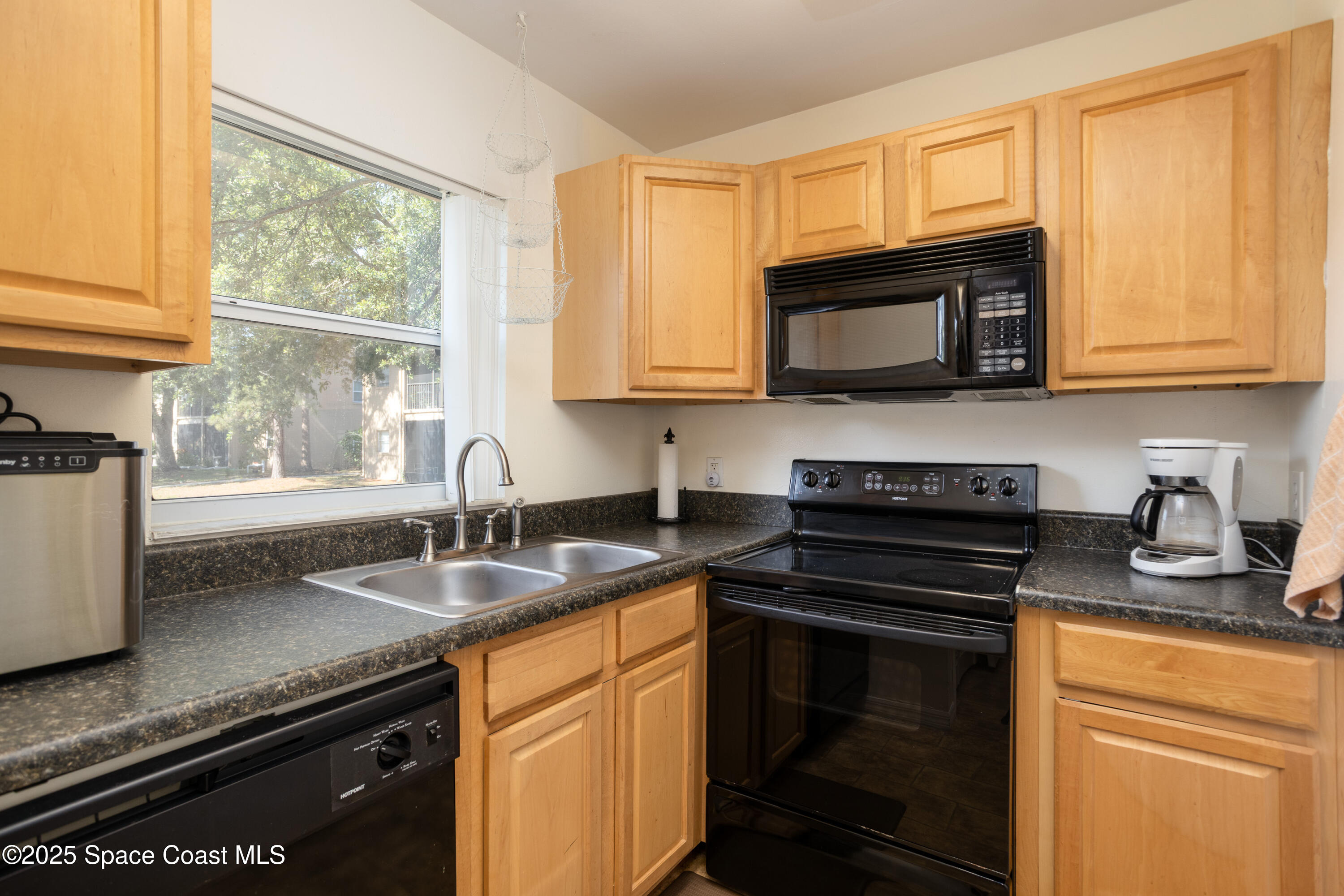 101 Summer Place, Unit 6 Merritt Island, FL 32953 - Photo 9 of 28 a kitchen with granite countertop a sink stove top oven and microwave