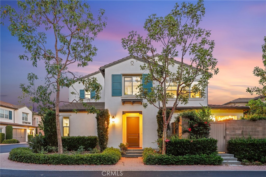 24 Lacebark, Unit 48 Irvine, CA 92618 - Photo 1 of 42 a front view of a house with a yard and garage