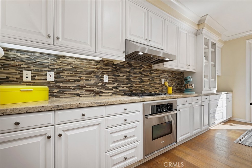 24 Lacebark, Unit 48 Irvine, CA 92618 - Photo 11 of 42 a kitchen with stainless steel appliances granite countertop a stove a sink and white cabinets