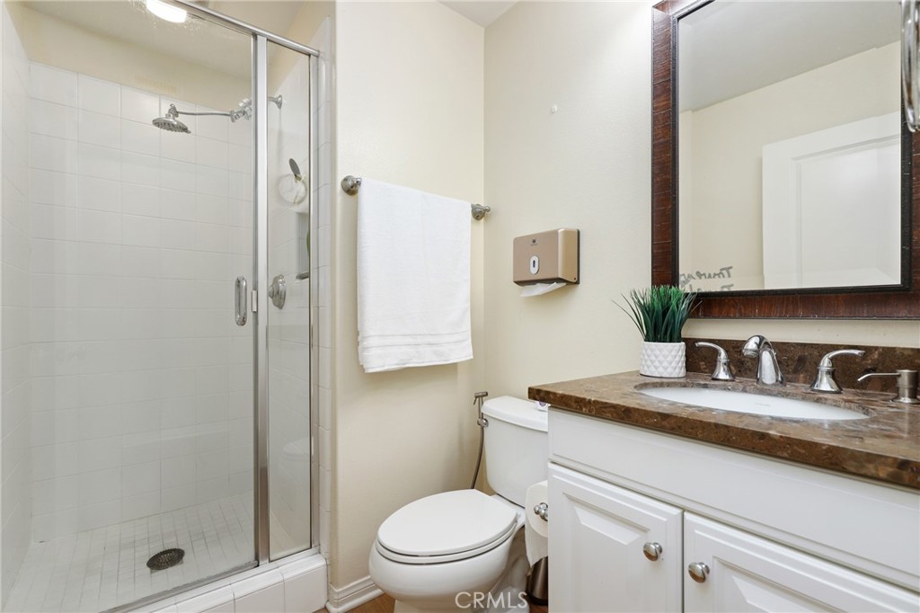 24 Lacebark, Unit 48 Irvine, CA 92618 - Photo 16 of 42 a bathroom with a granite countertop sink a toilet and shower