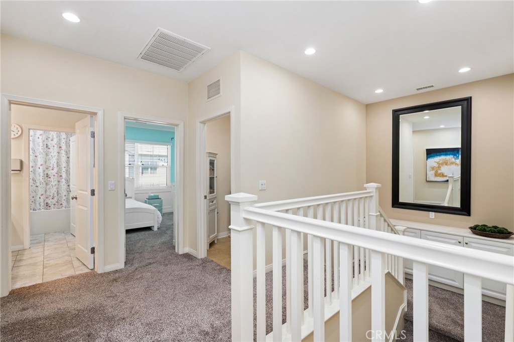 24 Lacebark, Unit 48 Irvine, CA 92618 - Photo 17 of 42 a view of a hallway with bedroom and wooden floor