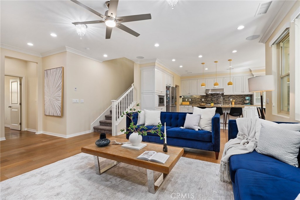 24 Lacebark, Unit 48 Irvine, CA 92618 - Photo 4 of 42 a living room with furniture kitchen view and a wooden floor