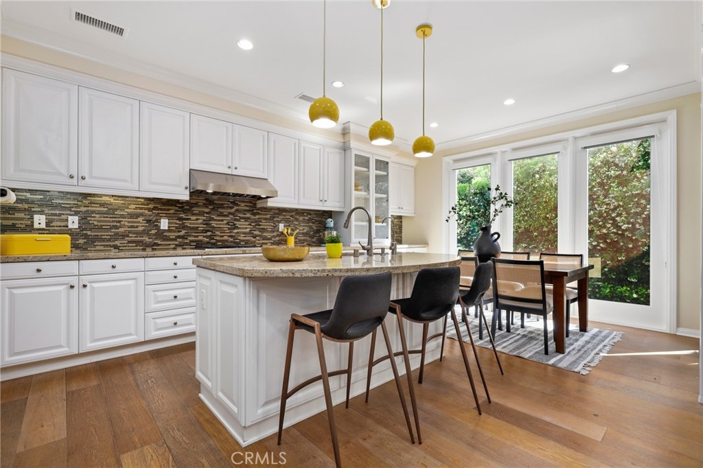 24 Lacebark, Unit 48 Irvine, CA 92618 - Photo 8 of 42 a kitchen with a table chairs stove and cabinets