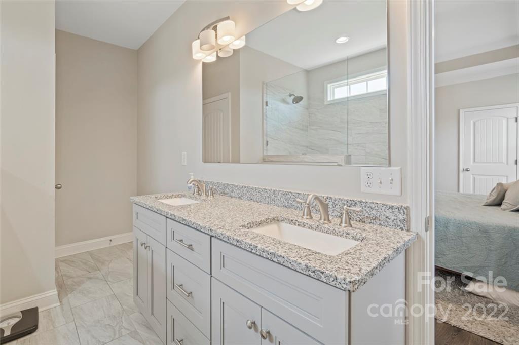 3269 Evondale Road Crouse, NC 28033 - Photo 21 of 36 a bathroom with a granite countertop sink a mirror and a shower