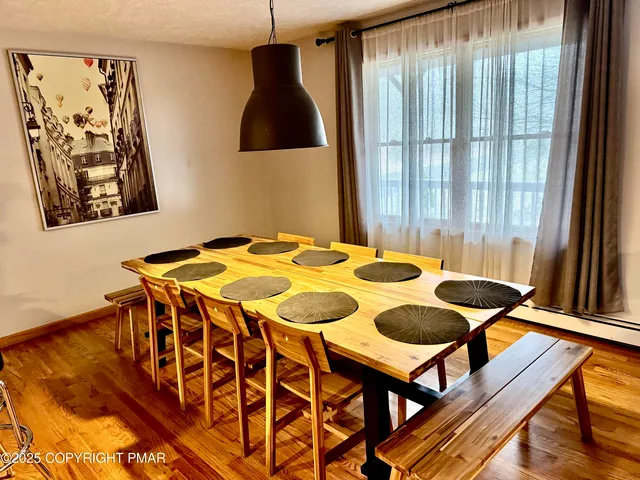 a large white kitchen with wooden floor and stainless steel appliances