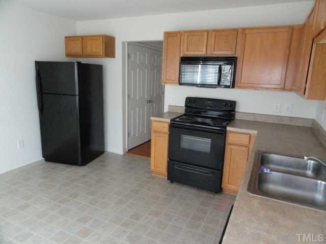 3441 Ferdilah Lane Raleigh, NC 27610 - Photo 3 of 12 a kitchen with a refrigerator and a stove