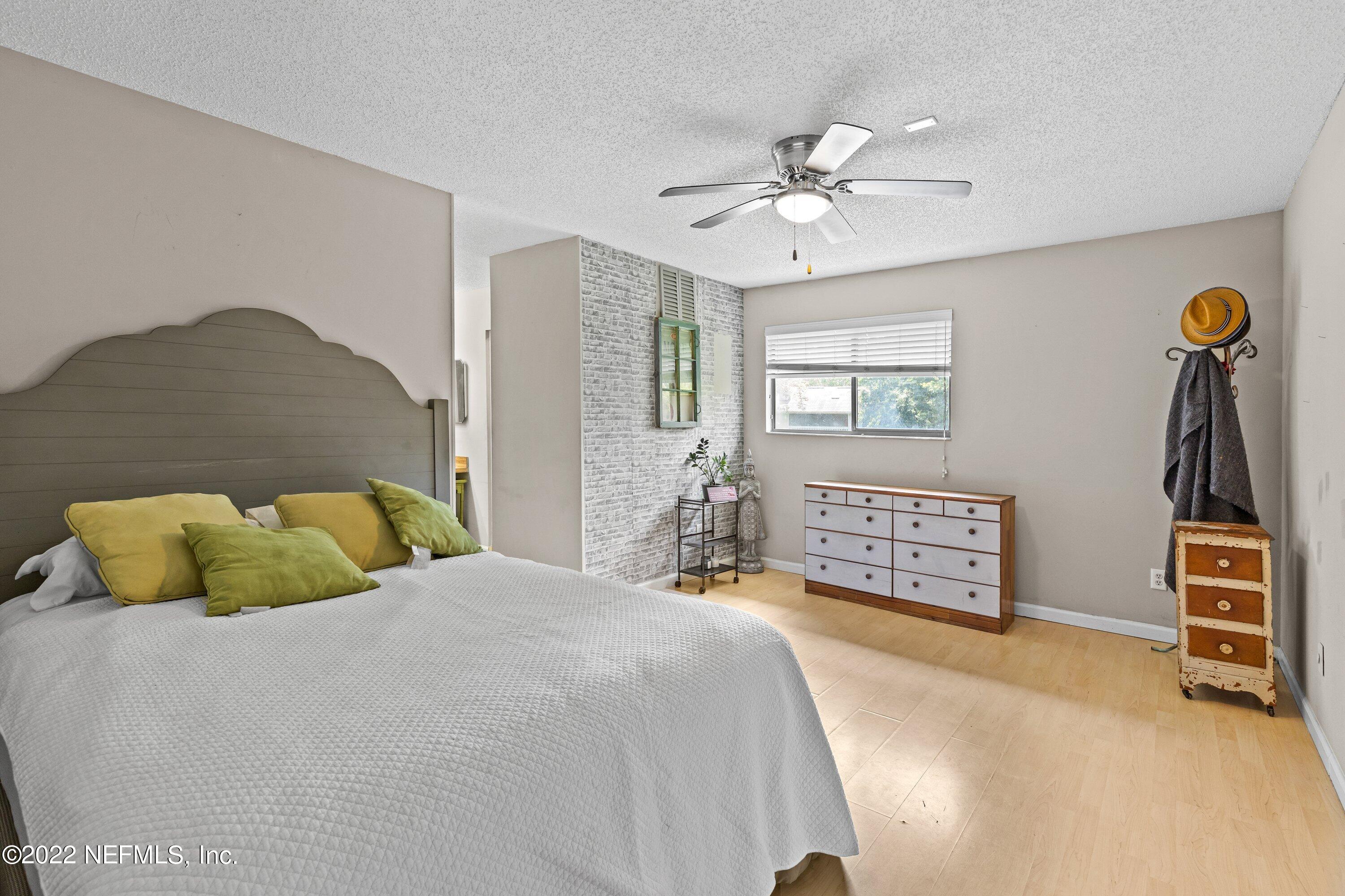 3801 Crown Point Road, Unit 2214 Jacksonville, FL 32257 - Photo 13 of 27 a bedroom with a bed a dresser and a chandelier